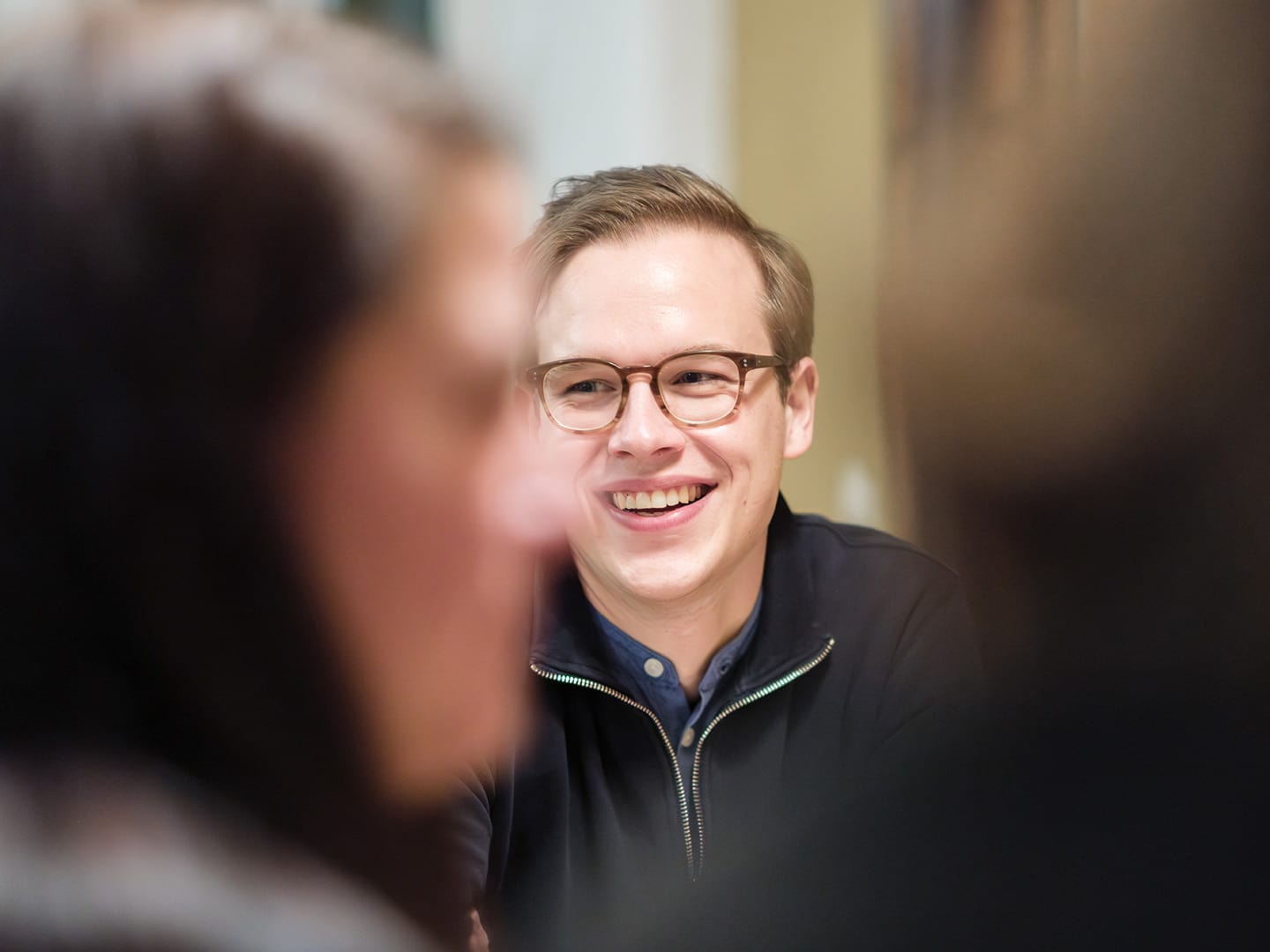 Lachende Person in Gesprächssituation im Büro